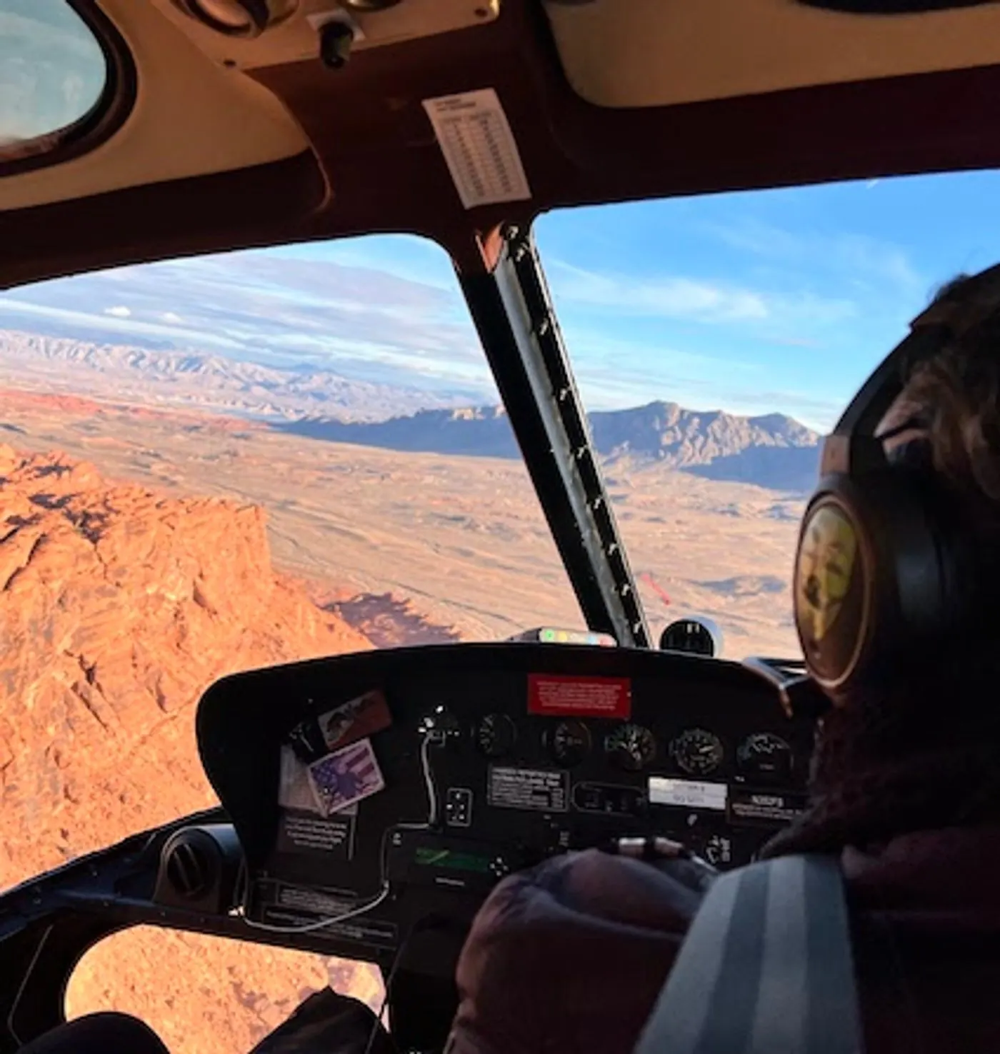 Close view of a 5 Star Airbus AS350 helicopter flying past red rock